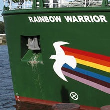 PIcture of the hull of the Rainbow Warrior, with a rainbow and dove painted across its bow.